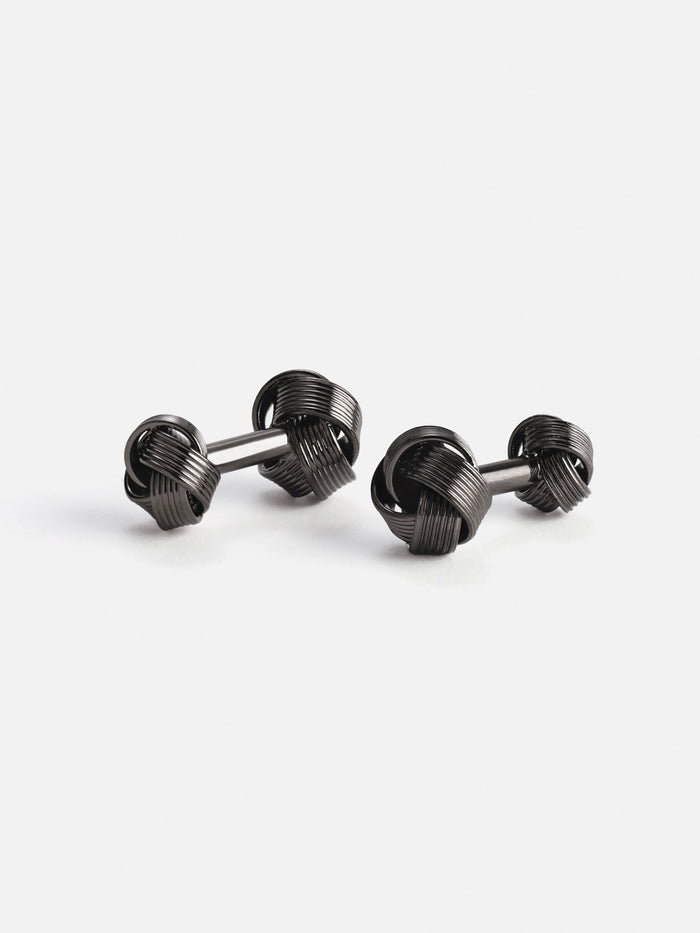 Two black knot cufflinks on a white background.