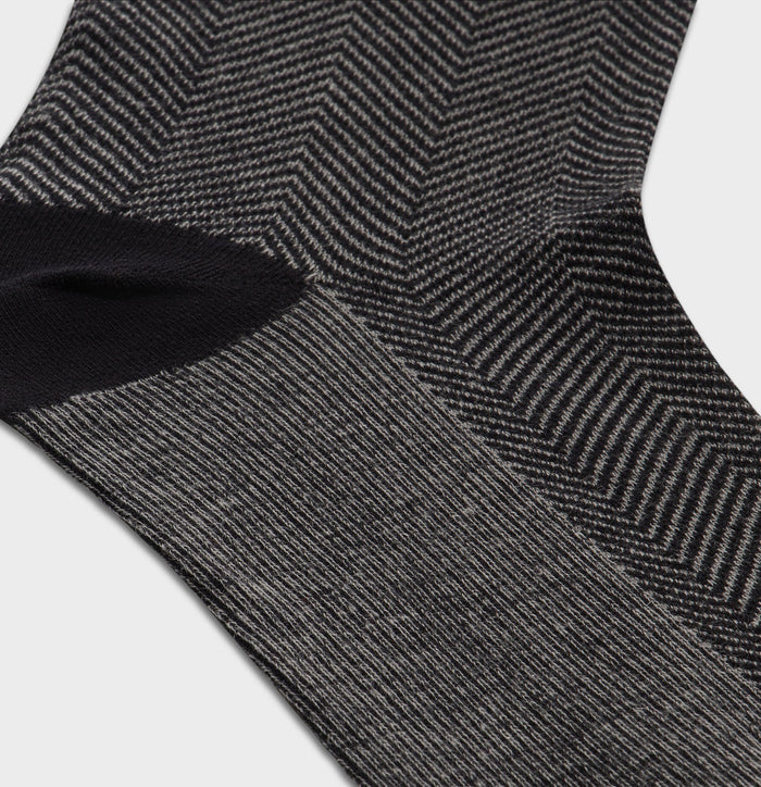 Close-up of black and grey herringbone knit pattern on a dress sock.
