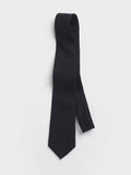 Black linen necktie looped and draped on a grey background.