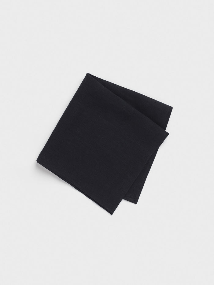 Folded black linen pocket square on a light grey background.