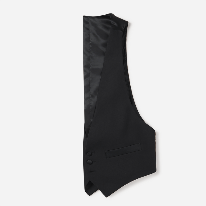 Black tuxedo vest flat lay, interior satin lining visible, grey background.