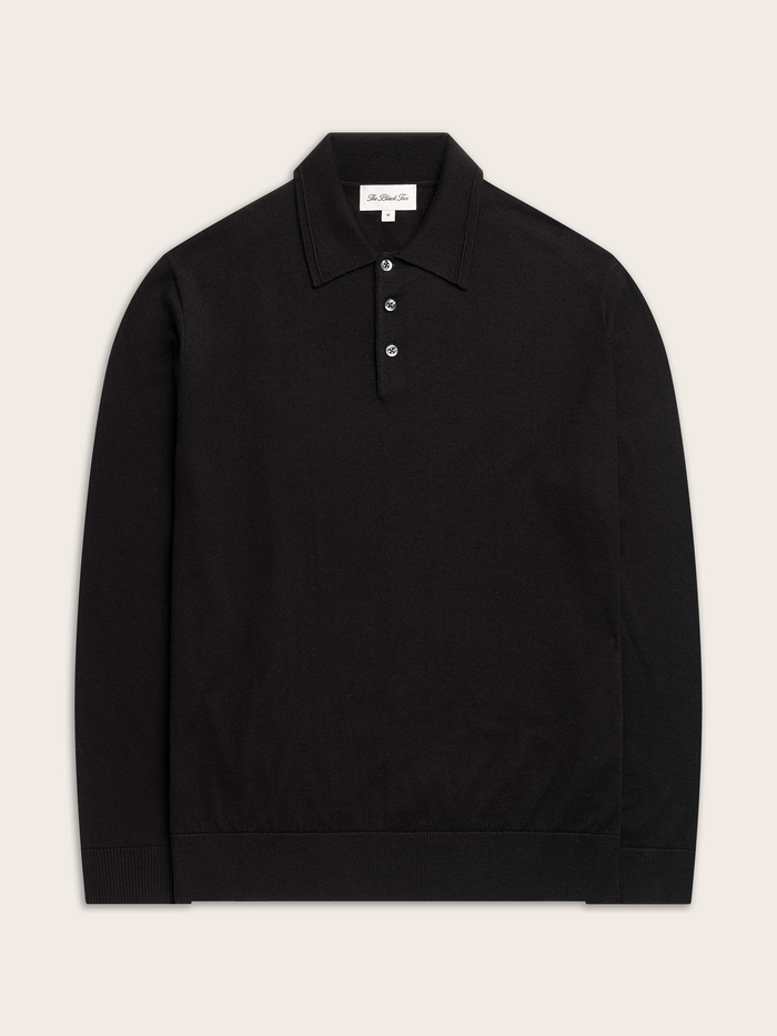 Black long-sleeve polo sweater, flat lay, cream background.
