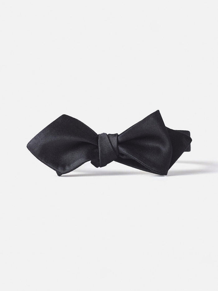 Black satin diamond-point bow tie with glossy finish laid flat on a white background