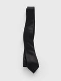 Black satin necktie looped and draped on a grey background.