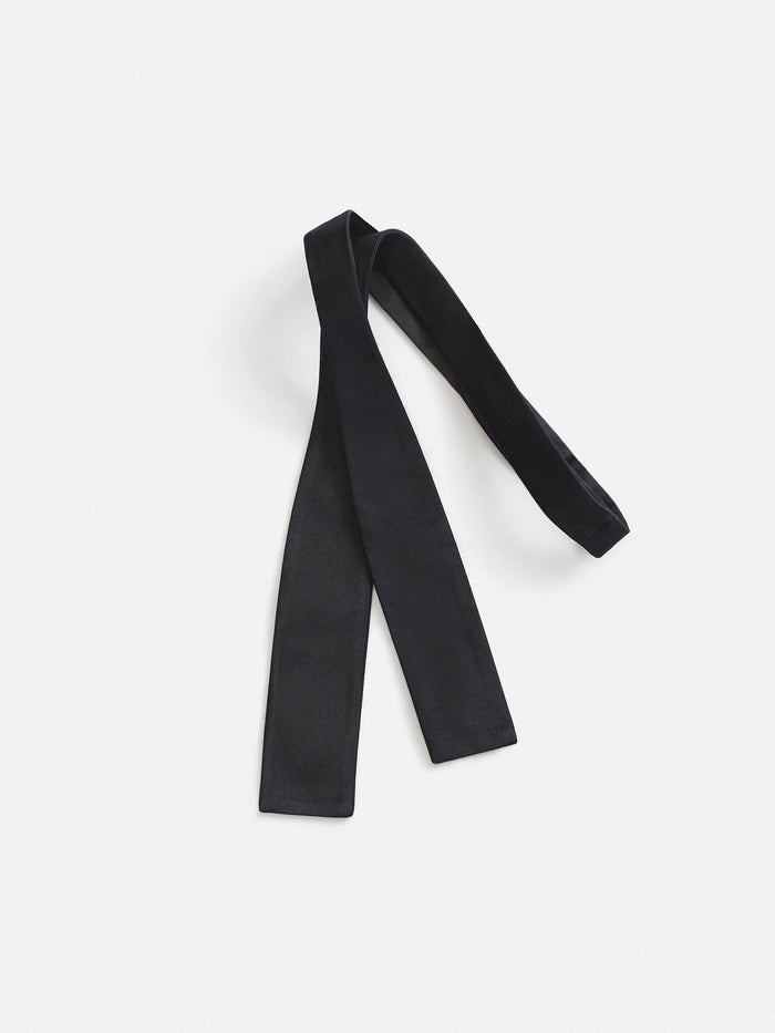 Black satin self-tie bow tie shown untied as a long strip on a white background