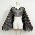 Black sheer tulle bridal cape with sequin embellishments and long flowing sleeves for modern wedding dress styling.