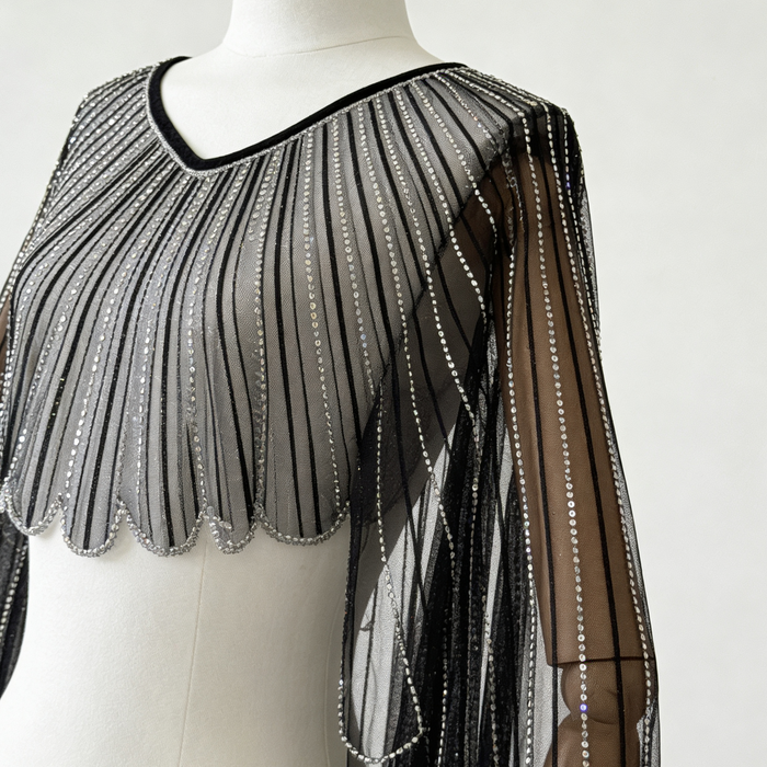 Black sheer tulle bridal cape with sequin embellishments and long flowing sleeves for modern wedding dress styling.