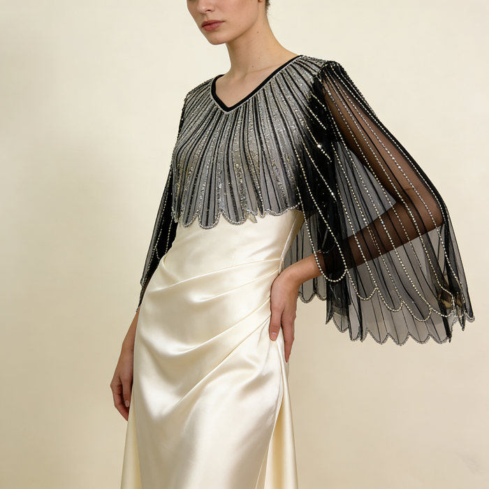 Black sheer tulle bridal cape with sequin embellishments and long flowing sleeves for modern wedding dress styling.