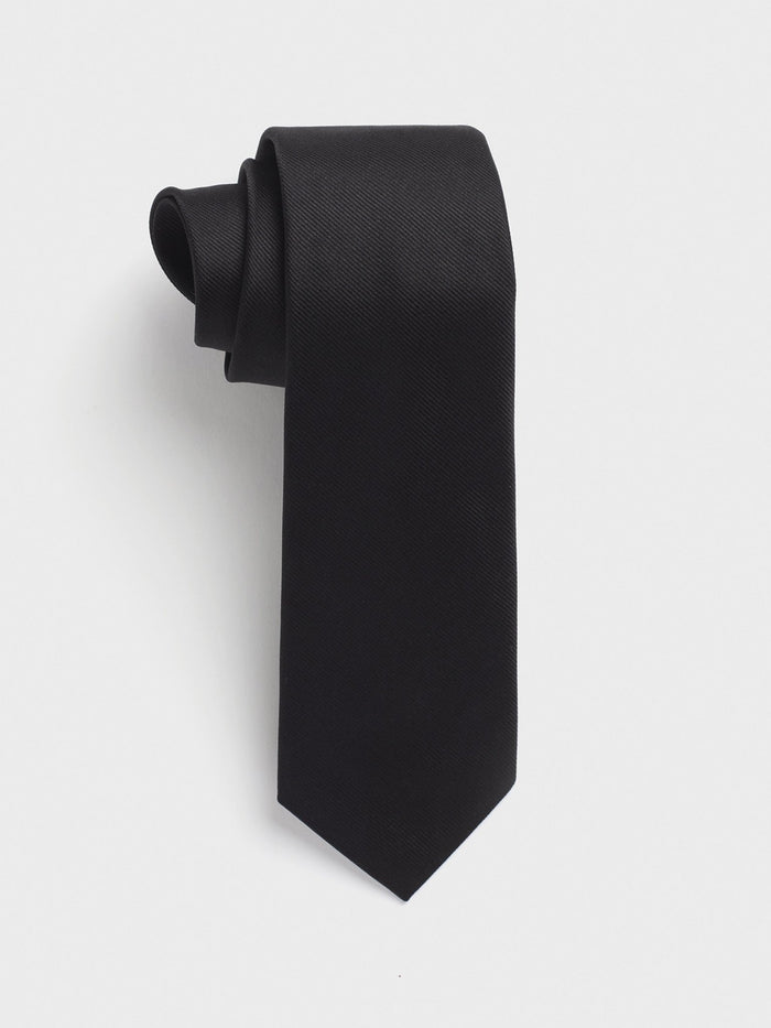 Black silk twill necktie loosely rolled on a white background.