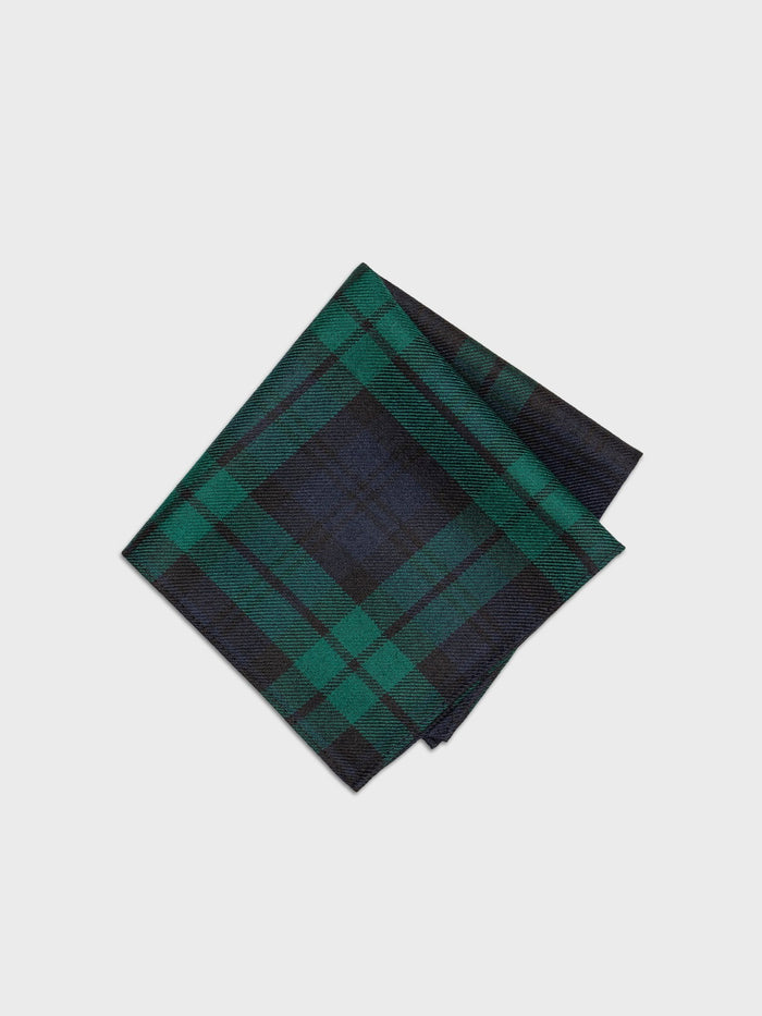 Black watch tartan pocket square, folded, on a grey background.