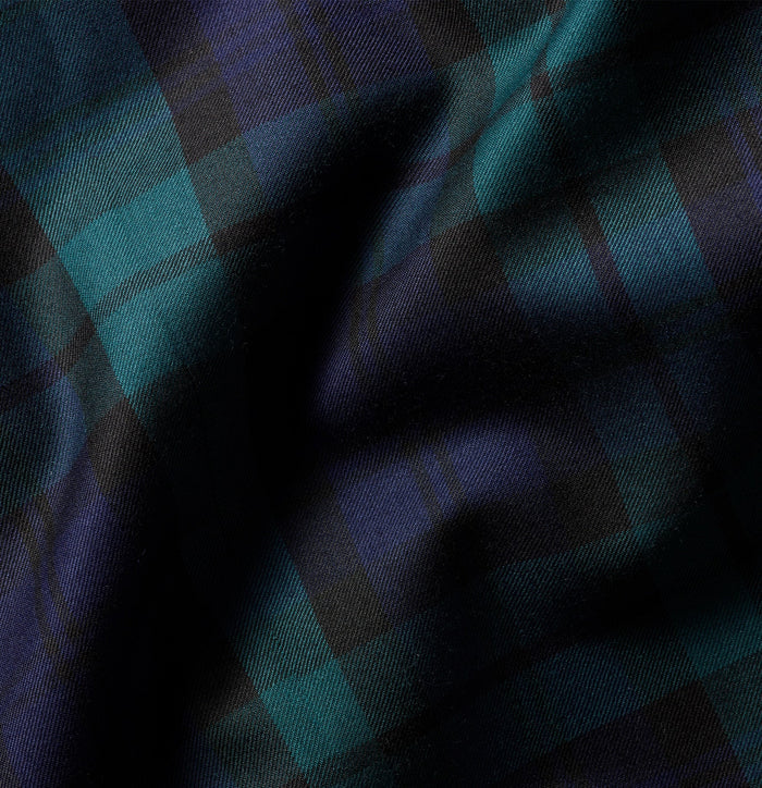 Close-up of black watch tartan fabric, draped to show plaid pattern.