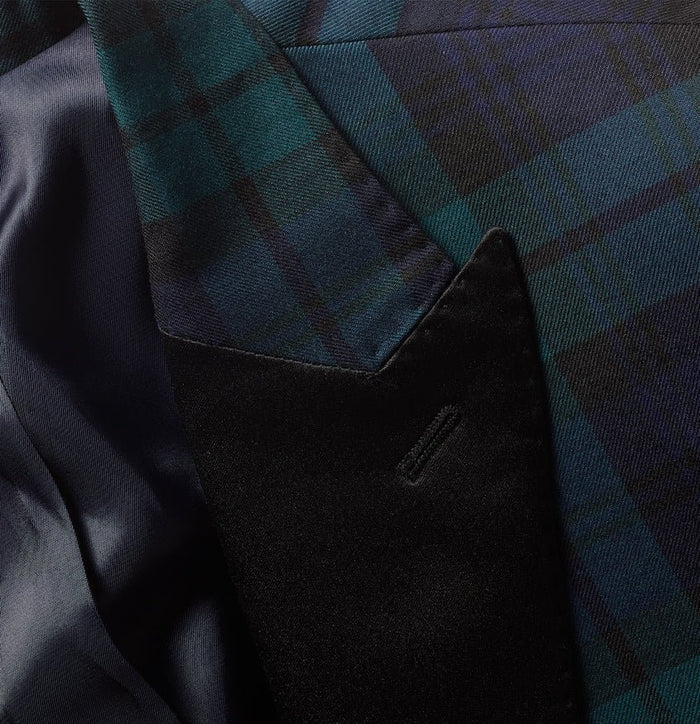 Close-up of black watch tartan jacket lapel and velvet pocket detail.