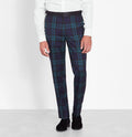 Close-up of black watch tartan tuxedo trousers, white shirt visible above.
