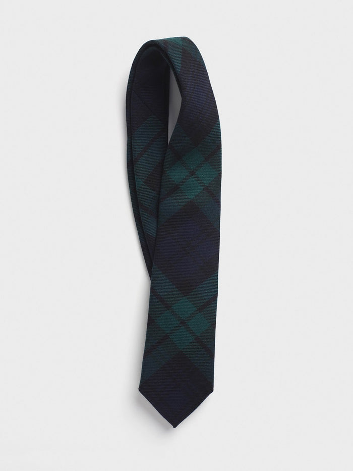 Black watch tartan wool necktie looped and draped on a grey background.
