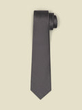 Black necktie with a pewter-grey diamond weave pattern, rolled on a beige background.