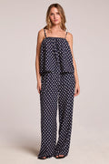 Full body front view of a woman wearing the Chaser  Blair Navy Spot Trouser and matching top on a neutral background