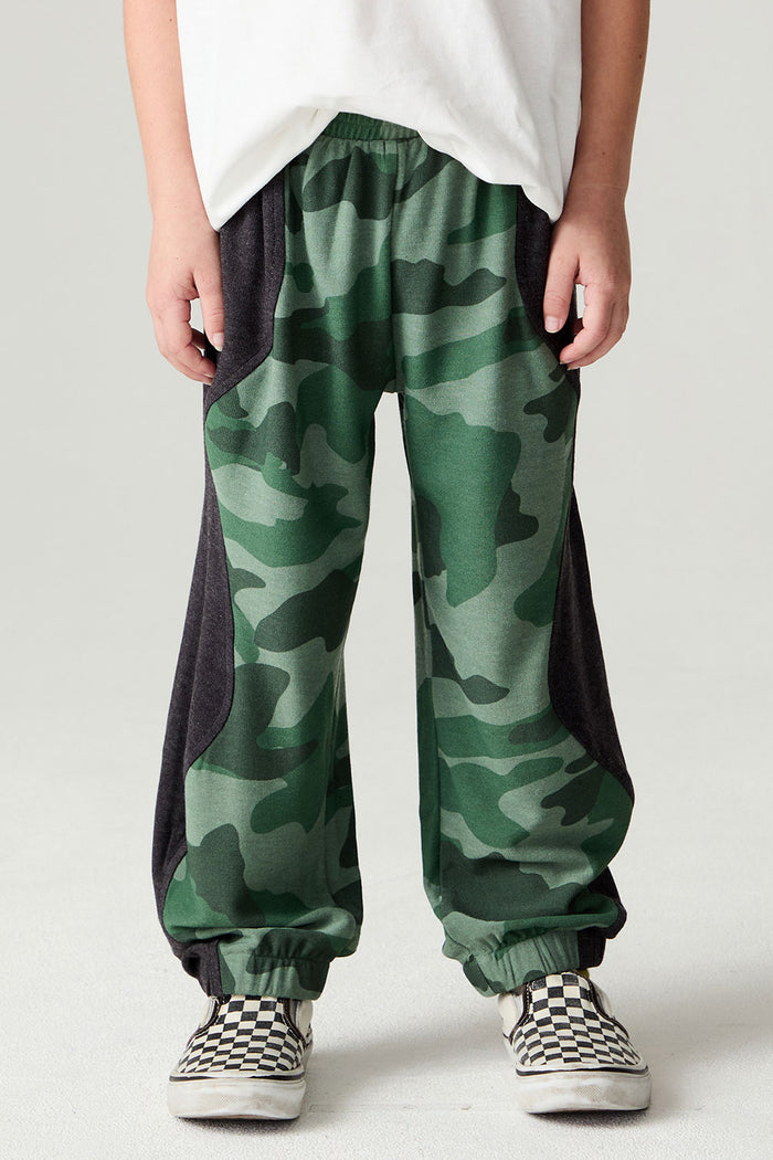Front view of a boy wearing the Chaser Blocked Camo Pants Boys Jogger on a neutral background with white tee  and sneakers