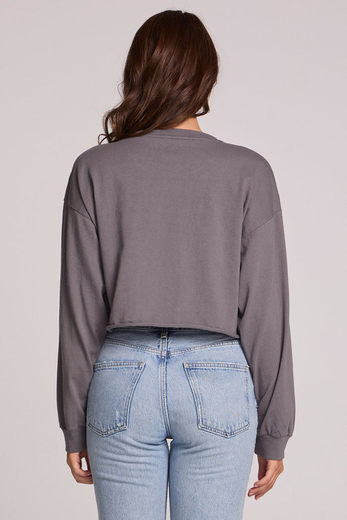 Back view of a woman wearing the Chaser Blondie Live Cropped Sweatshirt on a neutral background with hands at sides