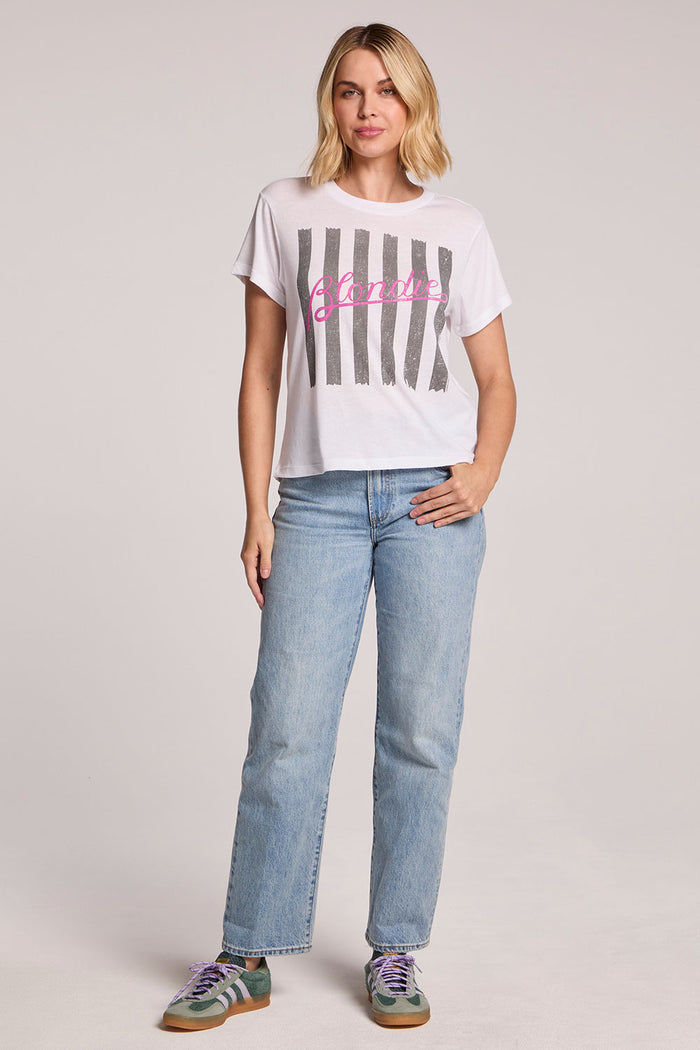 Full body front view of a woman wearing the Chaser  Blondie Parallel Lines Tee and sneakers on a neutral background