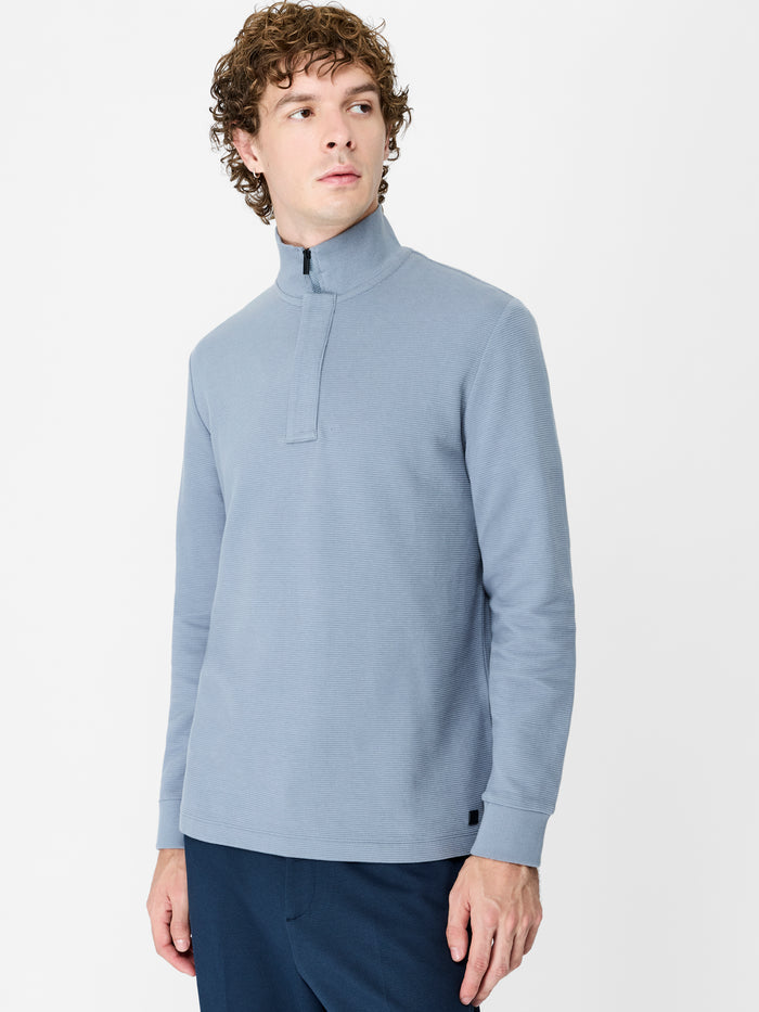 A man wearing a blue Sweatshirt with long sleeves, a funnel neckline, a branded half zip and a regular fit.