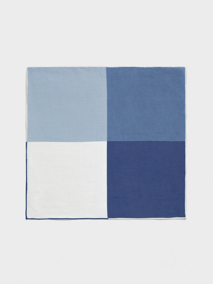 Blue and white quad-pattern pocket square laid flat, four-color block design.