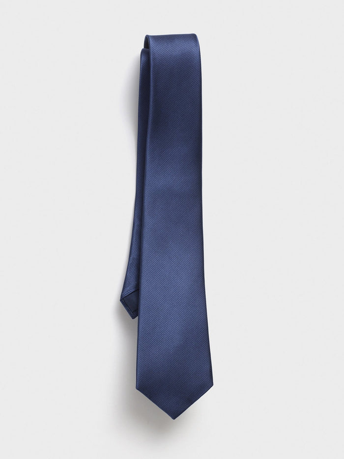 Blue silk necktie with a twill texture hanging against a white background.