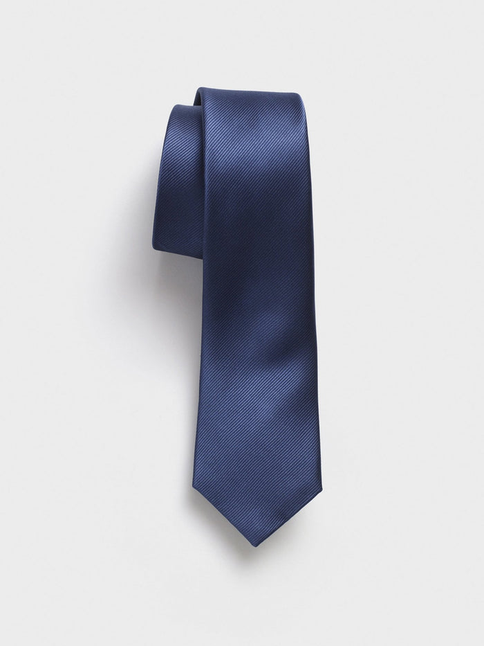 Blue silk necktie draped in a loose loop against a light grey background.