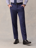 Cropped front view of a man in blue suit trousers, striped shirt, and black belt, hands in pockets