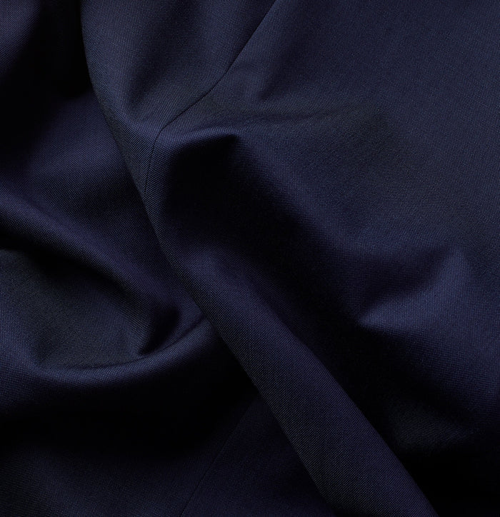 Close-up of blue suit fabric with soft folds and fine woven texture