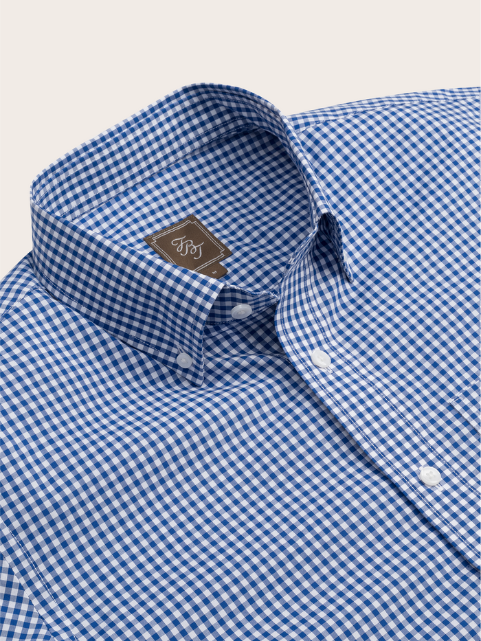 Close-up of a blue and white gingham shirt's collar and brand tag.