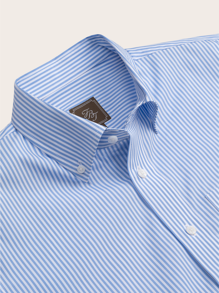 Close-up of a light blue and white striped shirt's collar and brand tag.