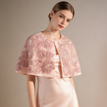 Handmade blush bridal cape with dimensional floral embroidery and delicate beadwork.