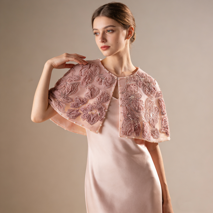 Luxury blush bridal cape featuring embroidered flowers, sequins and pearl accents.