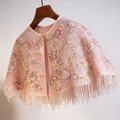Blush pink bridal capelet featuring floral embroidery, sequins and hand beaded pearl fringe on soft illusion tulle.