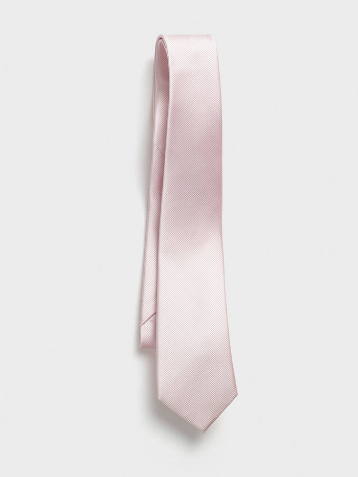 Blush pink silk tie draped in a twisted loop on a light grey background.
