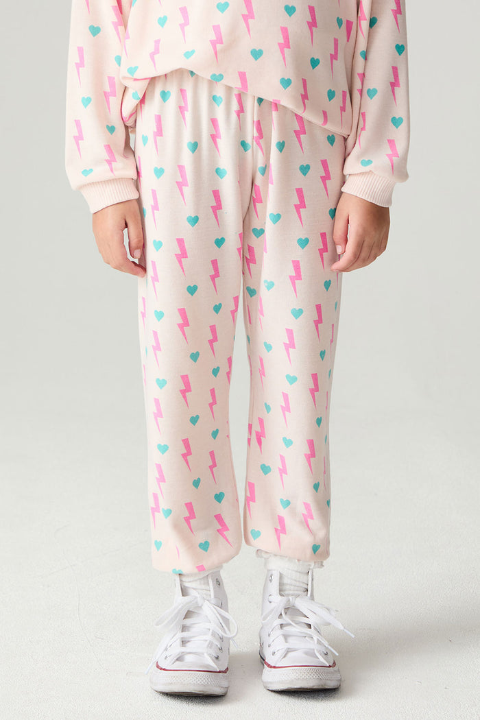 Front view of a girl wearing the Chaser Bolt Hearts Girls Jogger on a neutral background with matching long sleeve top