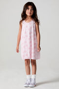 Front view of a girl wearing the Chaser Bows and Stars Dress and white shoes and socks on a neutral background