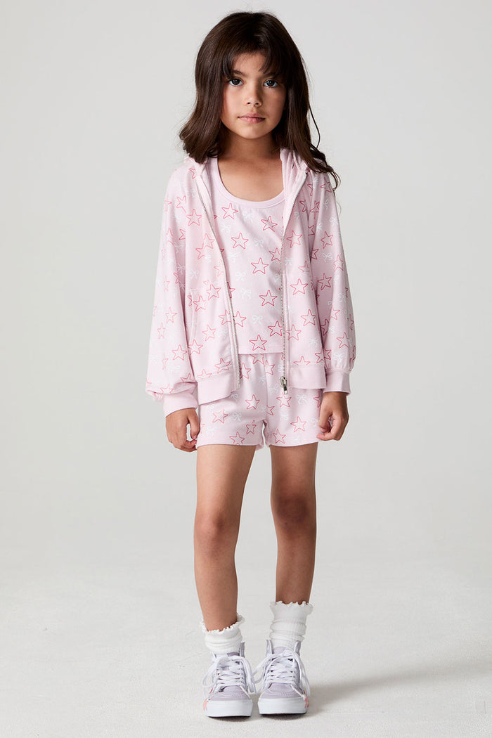 Front view of a girl wearing the Chaser Bows and Stars Zip-Up and matching  bow print shorts on a neutral background