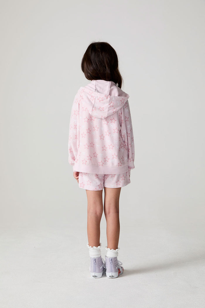 Back view of a girl wearing the Chaser Bows and Stars Zip-Up on a neutral background