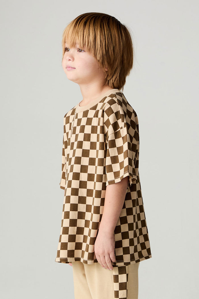 Side view of a boy wearing the Chaser Boys Solara Check Tee on a neutral background with matching pants