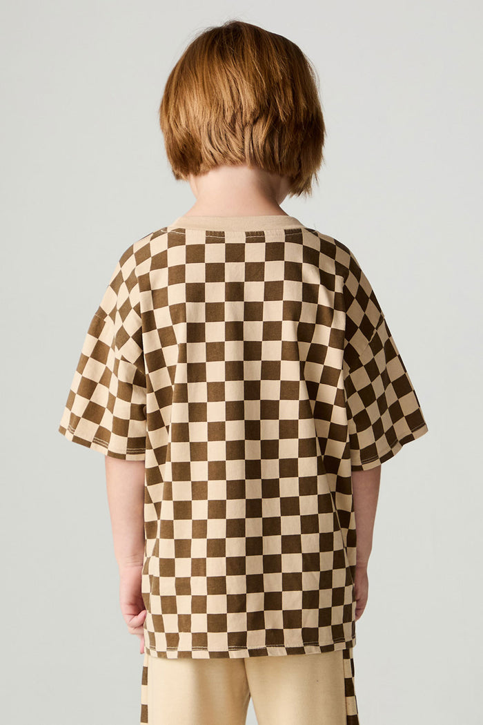 Back view of a boy wearing the Chaser Boys Solara Check Tee on a neutral background with pants