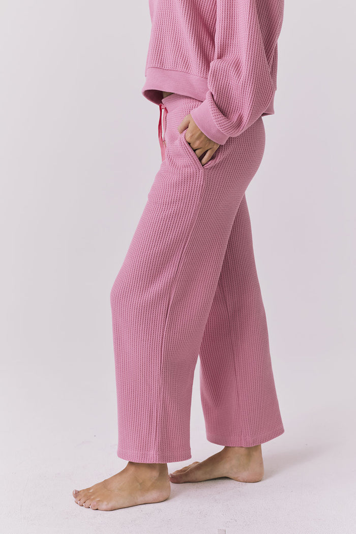 Side view of Chaser Brandy Crop Joggers in Sugar Magnolia highlighting the waffle knit fabric, side pocket detail, and relaxed lounge fit