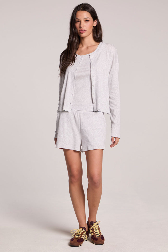 Front view of a woman wearing the Chaser  Brandy Light Heather Grey Button Up and sneakers on a neutral background