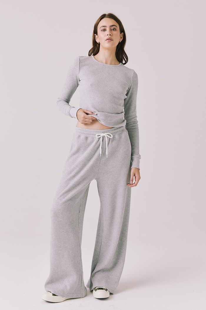 Full body view of woman wearing Chaser’s Brandy Light Heather Grey Joggers with matching Spritz Long Sleeve on a white background.