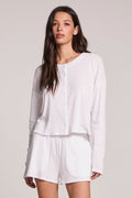 Front view of a woman wearing the Chaser  Brandy Button Up and shorts on a neutral background