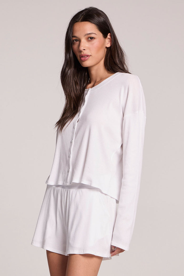 Side angle view of a woman wearing the Chaser Brandy Button Up on a neutral background with arms at her sides