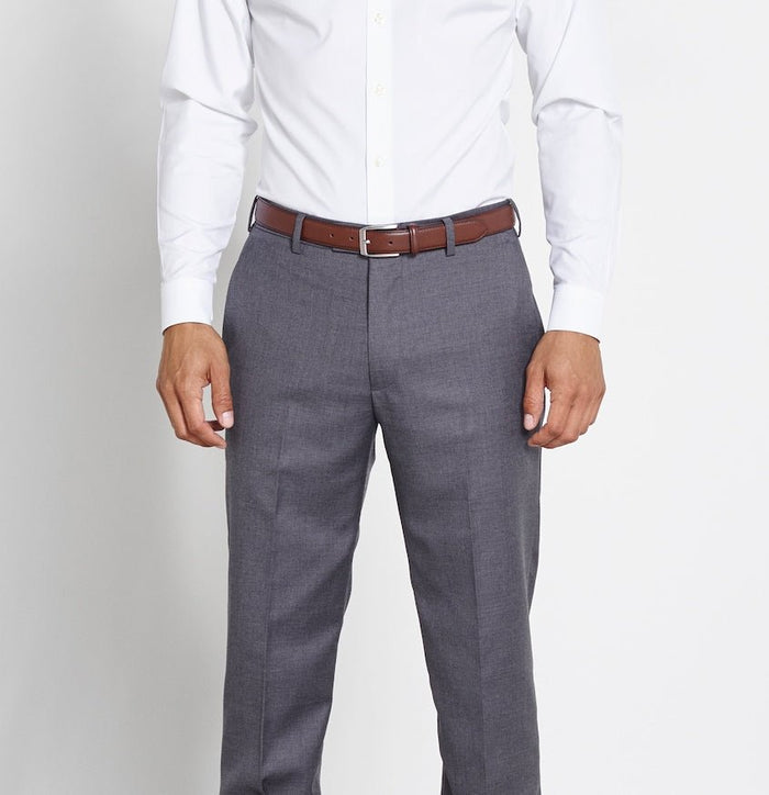 Close-up of a man wearing a brown leather belt with grey trousers and a white shirt.