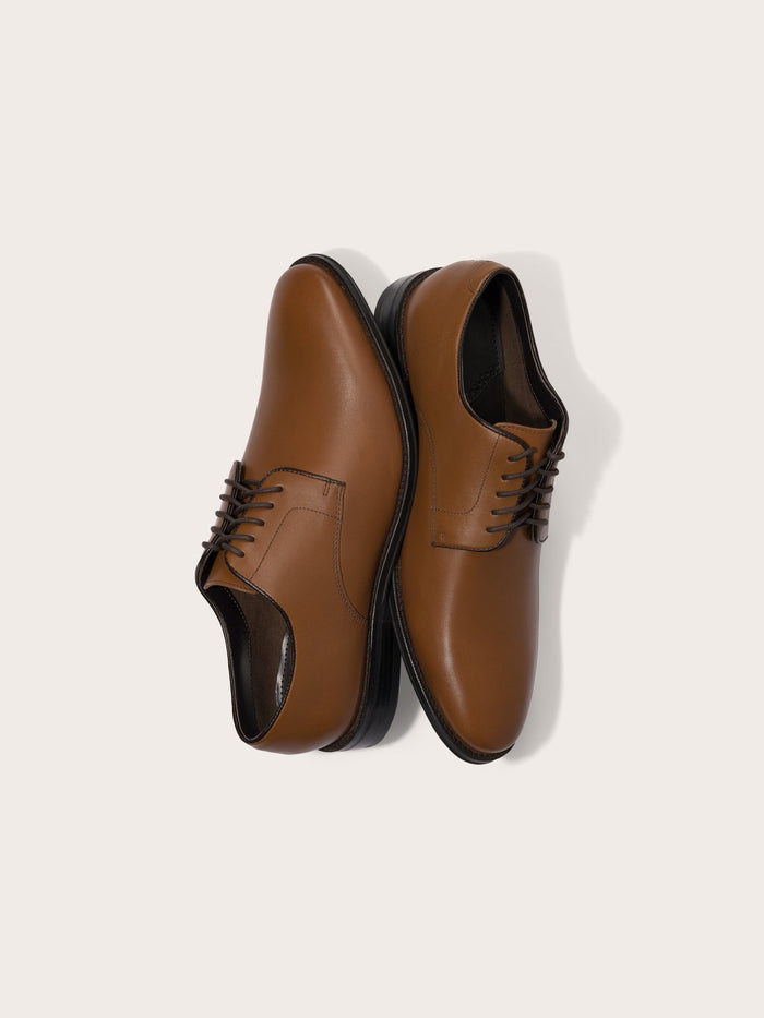 Pair of brown leather derby shoes, top-down view with laces and dark trim.