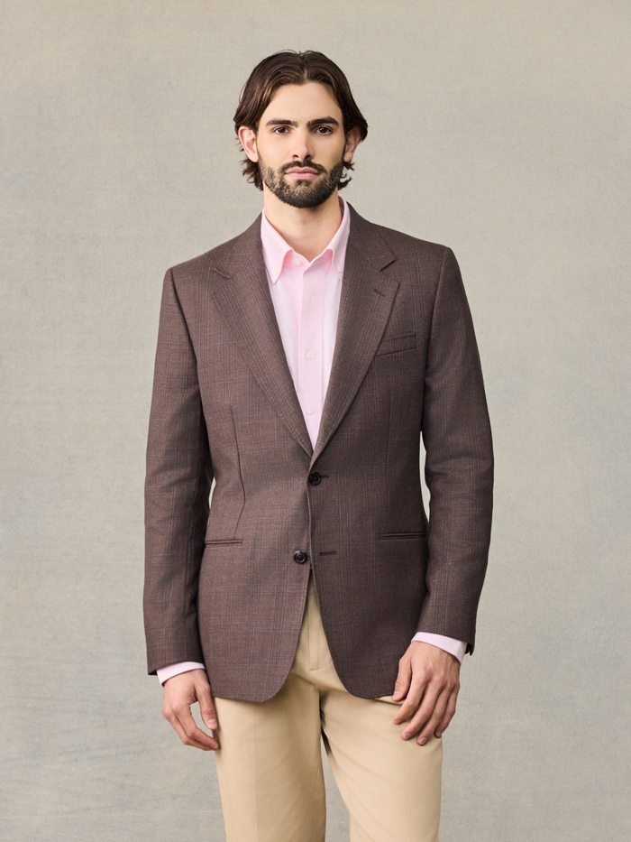 Man in a brown plaid sportcoat over a pink shirt, cropped front view.
