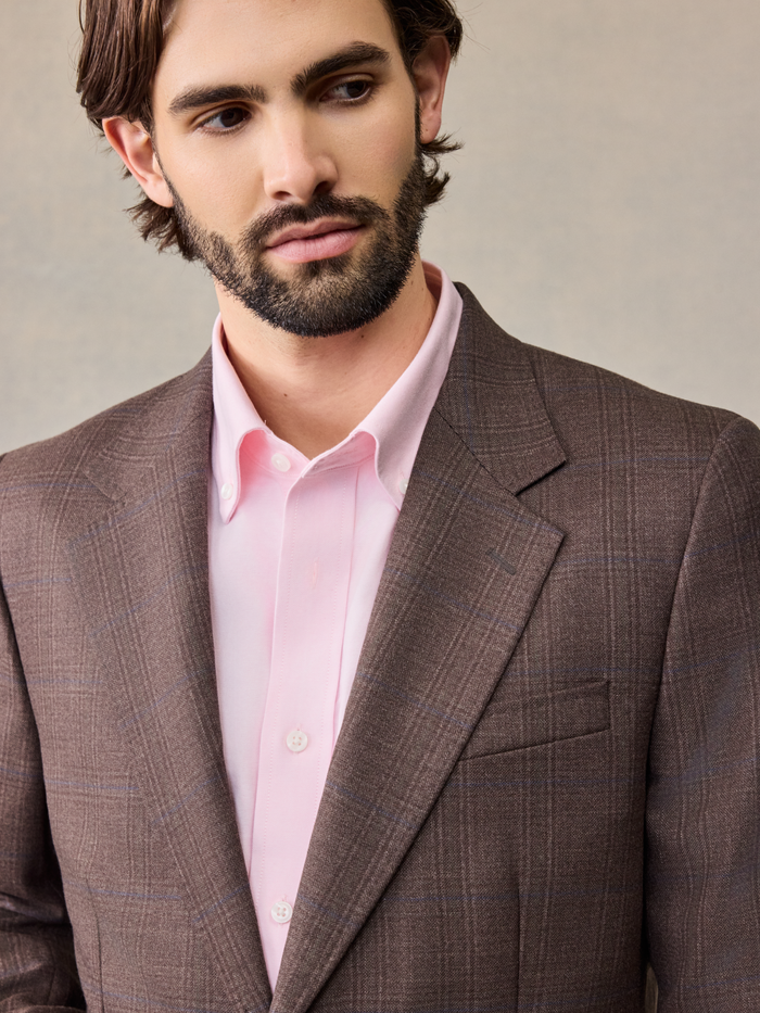 Close-up of a brown plaid sportcoat lapel and pink shirt collar.